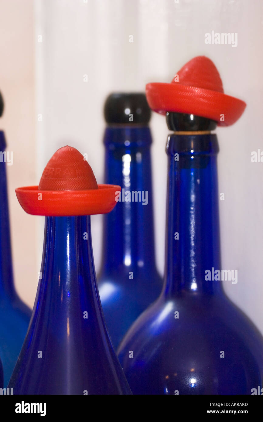 Sherry verre bleu portant des bouteilles en plastique rouge chapeaux mexicains trouvés sur certaines marques de tequila Banque D'Images