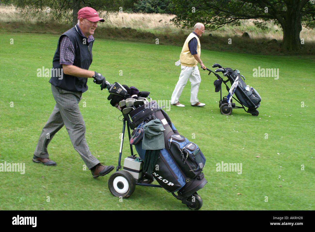 Les golfeurs à marcher le long de leur balle fairway Banque D'Images
