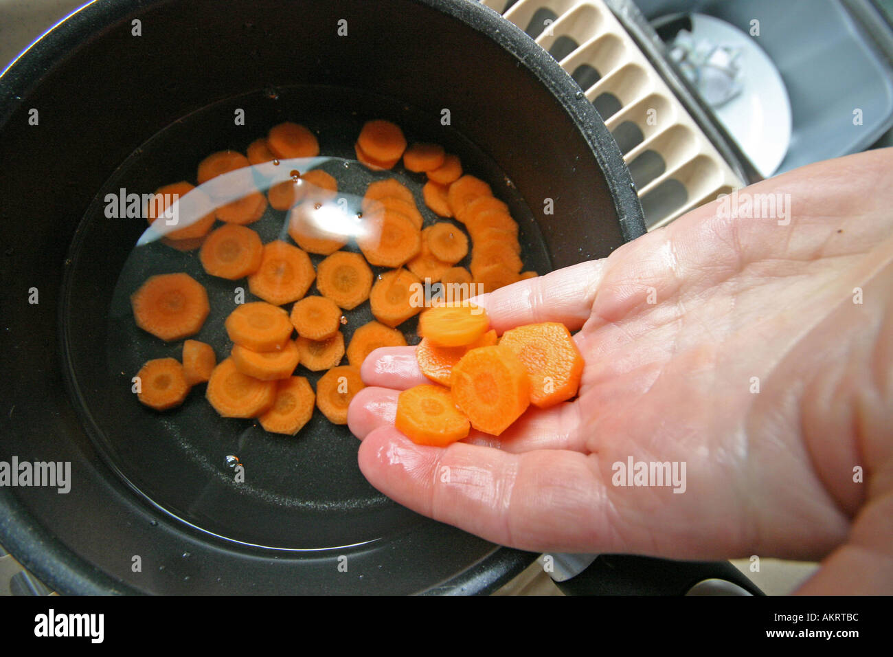 Dame mettre les carottes dans une casserole Banque D'Images