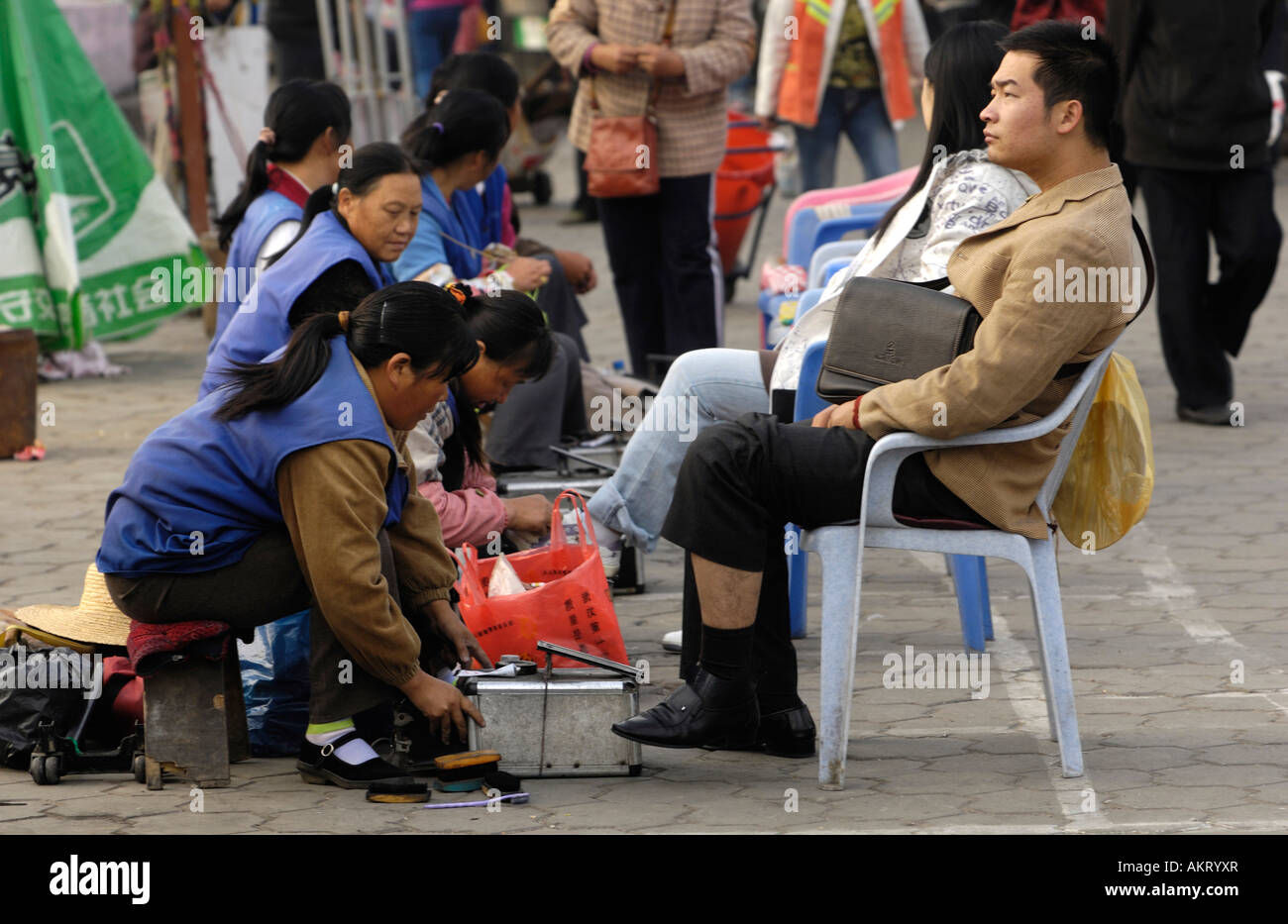Femme chinoise nettoie chaussures pour un homme d'affaires dans la province de Hubei Wuhan Chine 20 OCT 2006 Banque D'Images