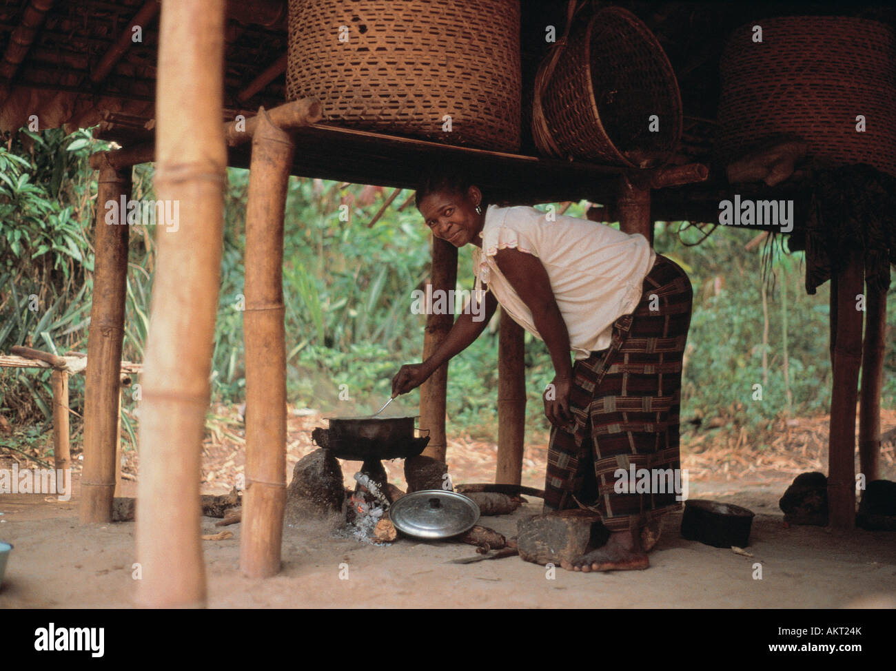 Une femme pygmée la cuisson sous sa maison au Zaïre Afrique Centrale Banque D'Images