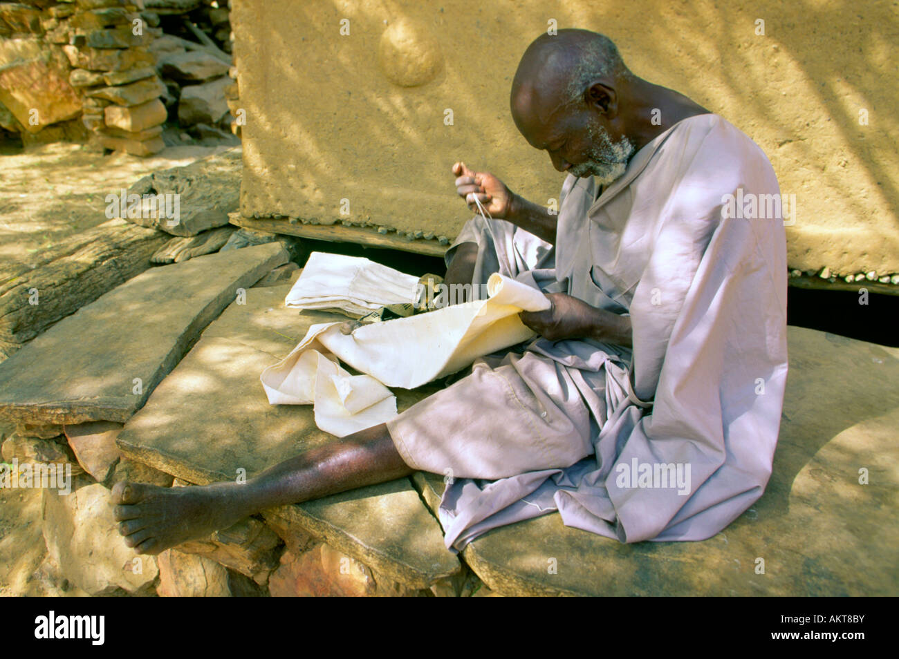 Village Dogon homme coud un boulon de coton tissé Banque D'Images