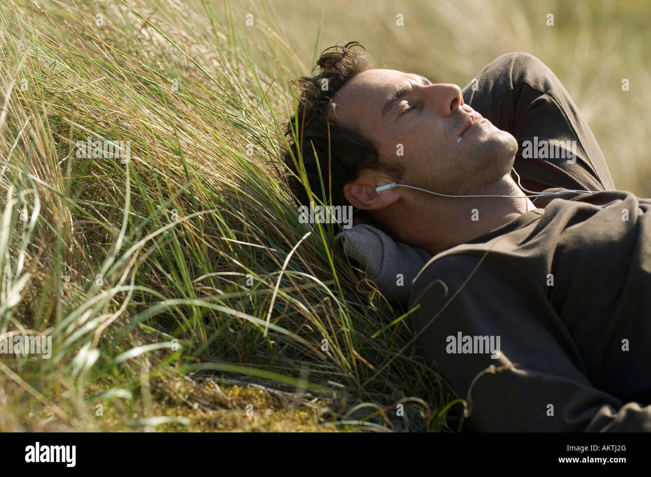 Homme étendu dans l'herbe, se détendre Banque D'Images