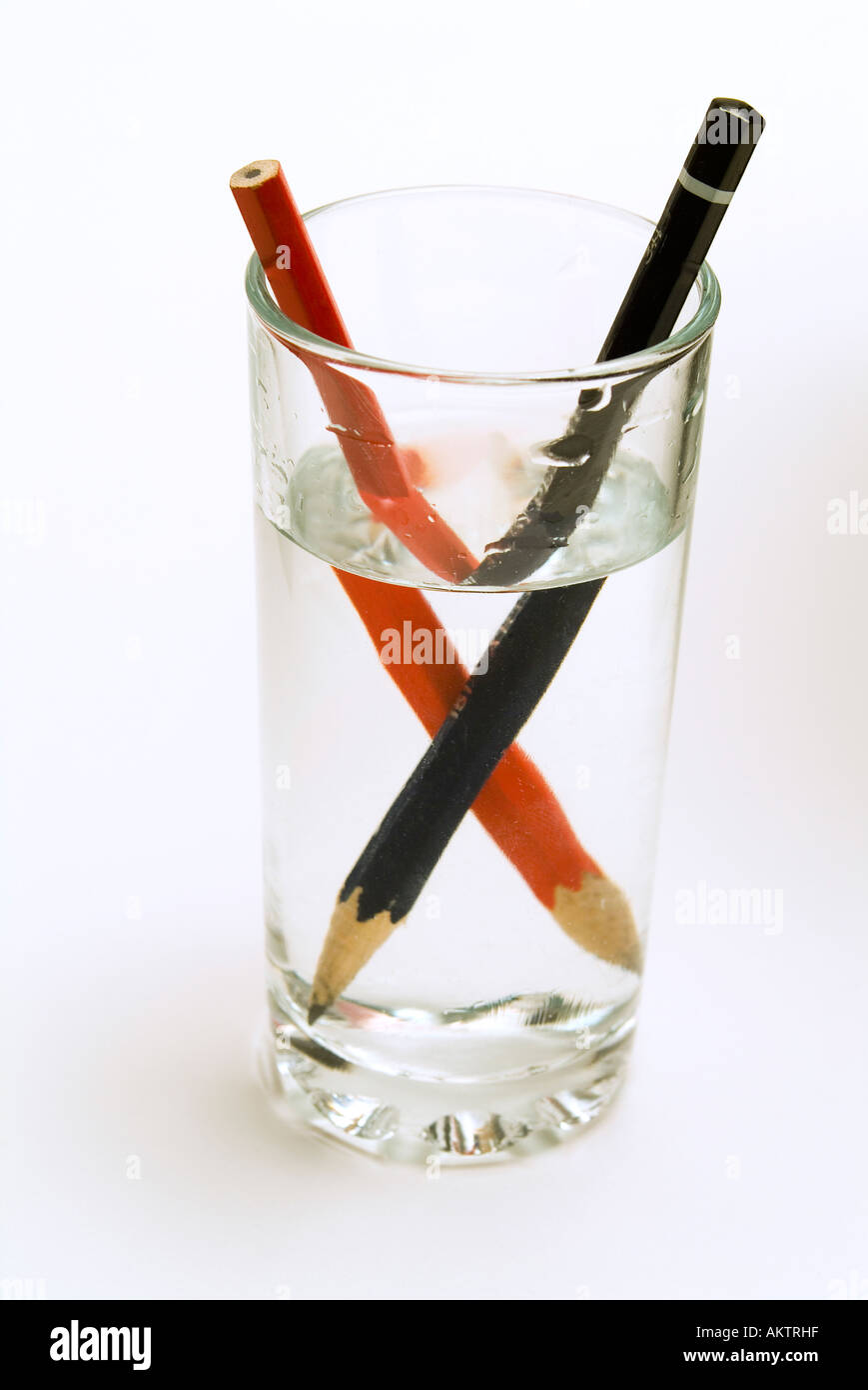 Deux crayons dans un verre d'eau, montrant le distoprtion optique causé par  la réfraction de l'image Photo Stock - Alamy