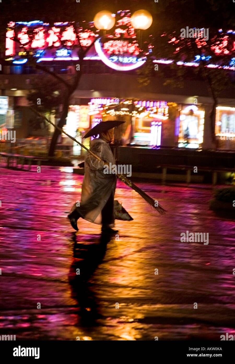 Street Sweeper dans la pluie dans la nuit hong kong Banque D'Images