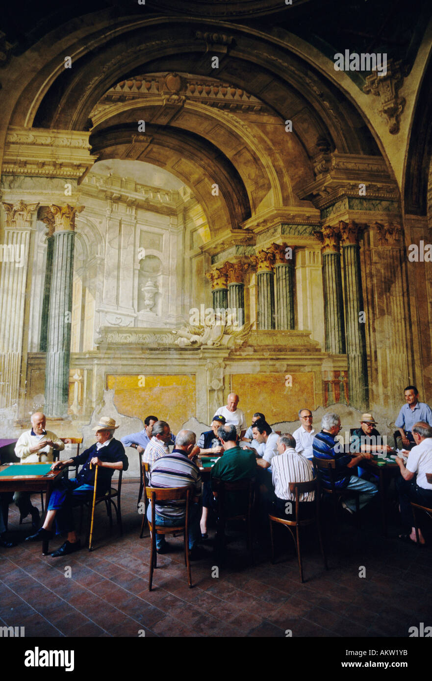 Sorrente. Italie. Un groupe d'hommes italiens se réunissent pour jouer à des cartes sur fond de fresques en fading dans la Sedil Dominova. Banque D'Images