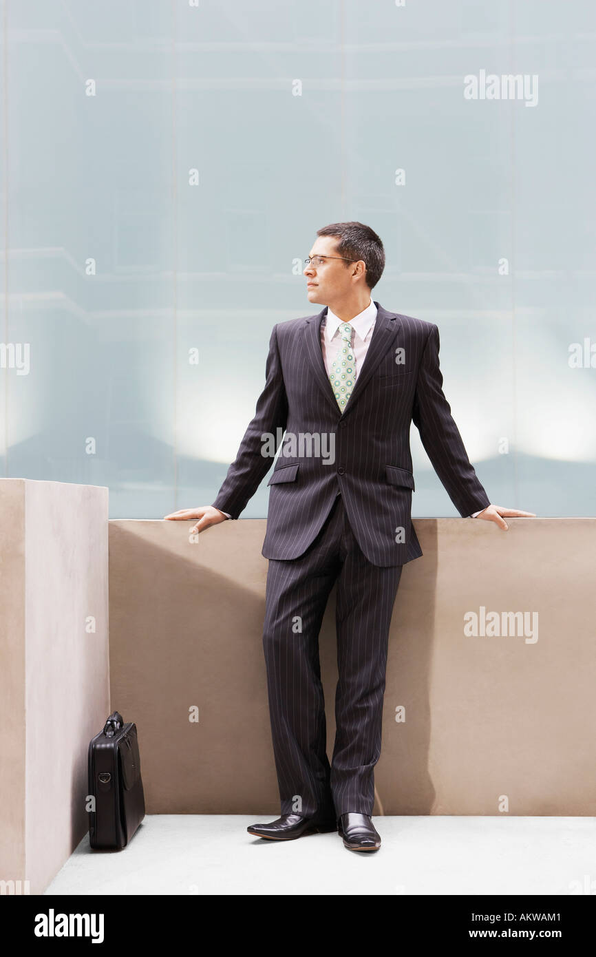 Businessman leaning on wall, portrait Banque D'Images