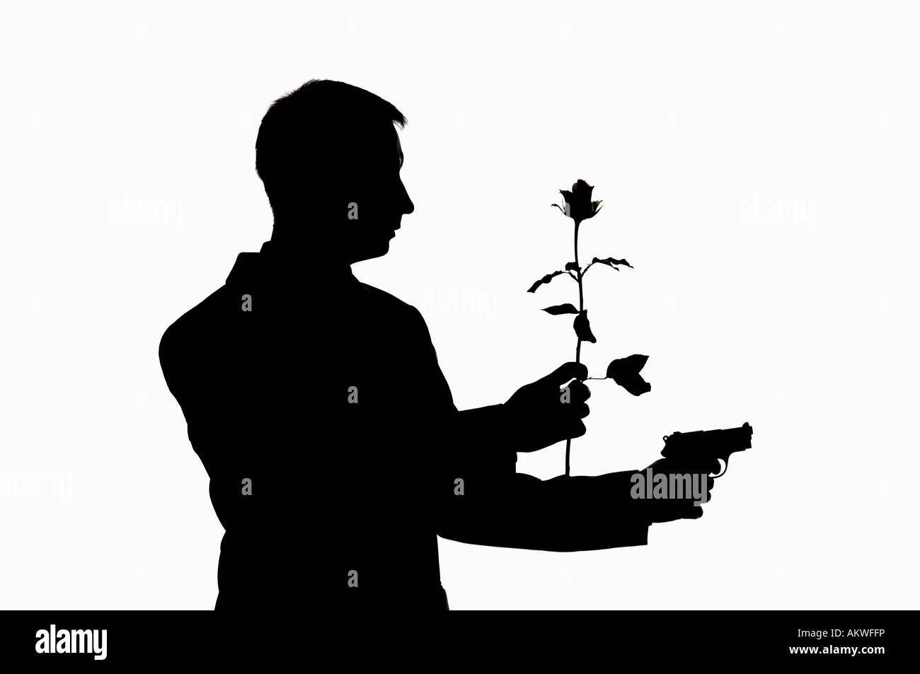 Man holding gun et rose, silhouette Banque D'Images