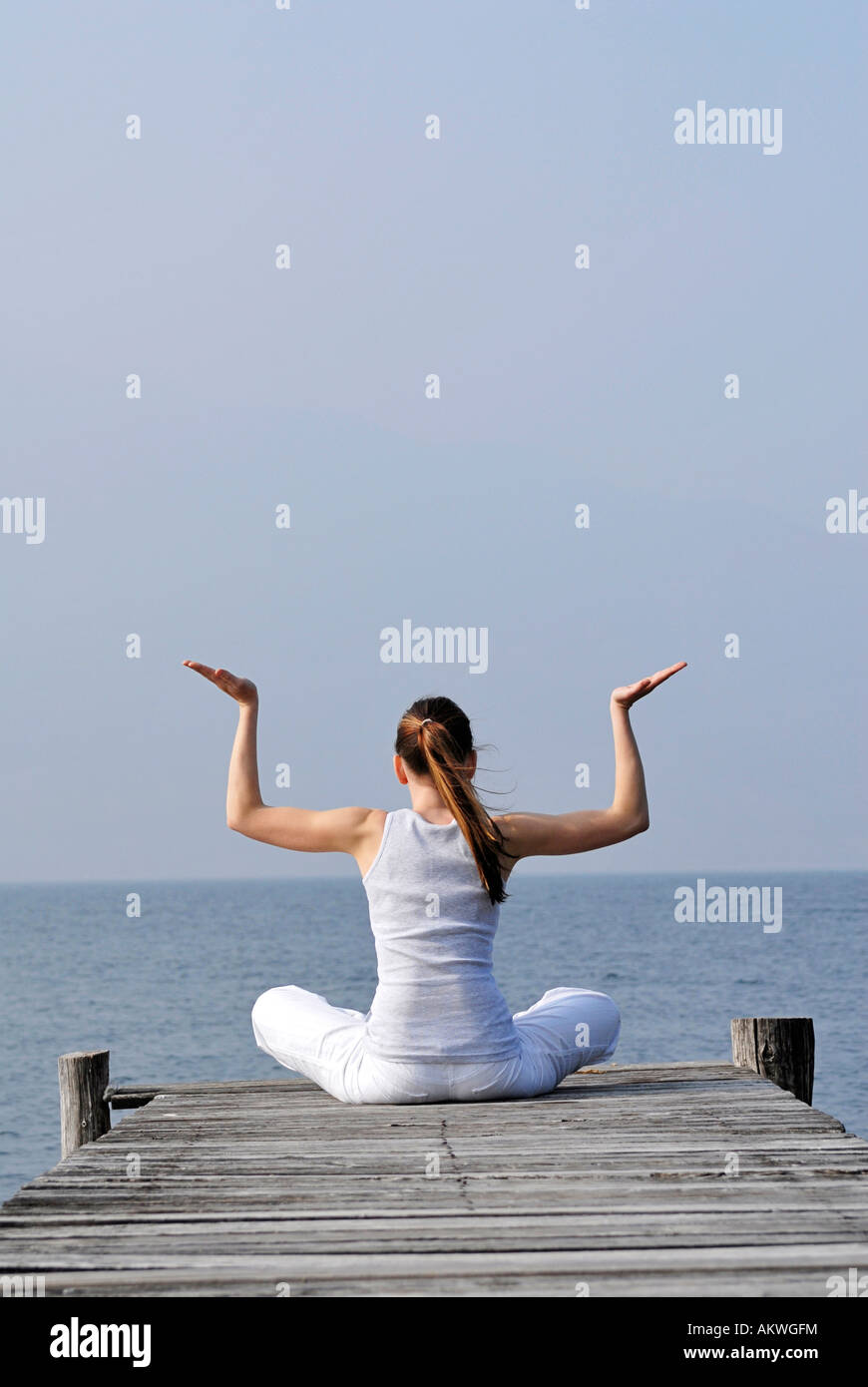 L'Italie, le lac de Garde, la femme (20-25) l'exercice de yoga on jetty Banque D'Images
