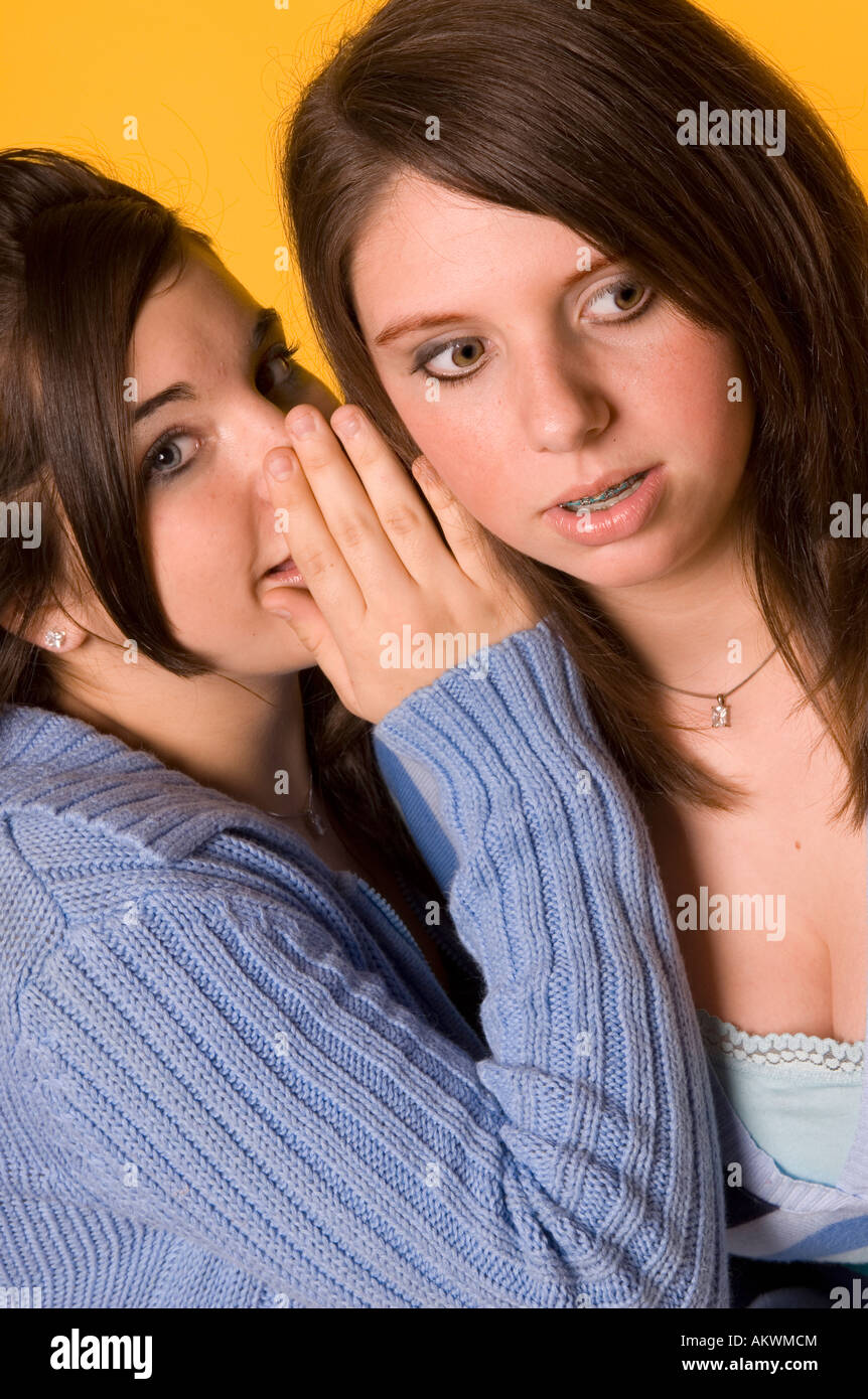 Portrait of Girl (15-17) Whispers choquant secret dans l'oreille de son ami USA Banque D'Images