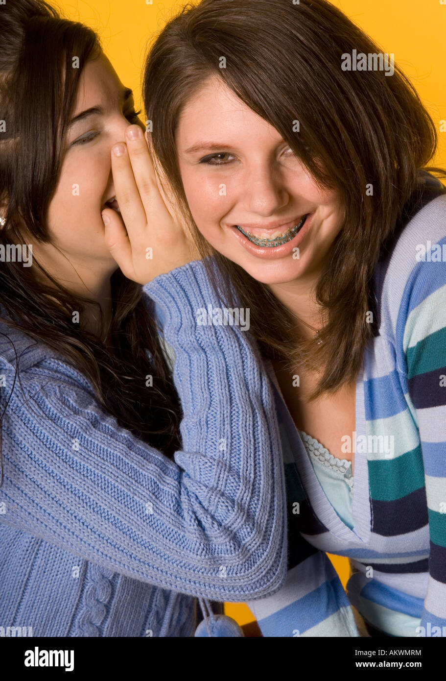 Portrait of Girl (15-17) Whispers Funny secret dans l'oreille de son ami USA Banque D'Images