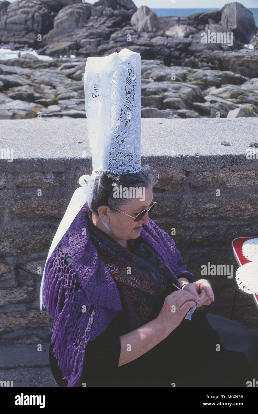 Une vieille dentellière avec un châle drapé sur ses épaules et une coiffe bigouden keof bleo traditionnelles travaillant sur un diagramme circulaire Banque D'Images