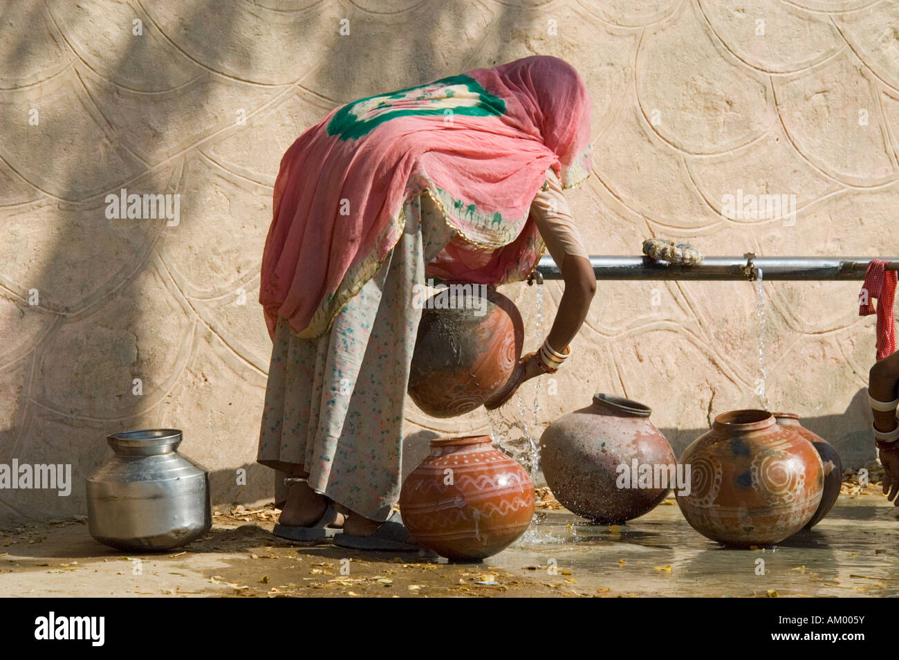 Une femme tire du Rajasthan l'eau du robinet dans village Nimaj, Rajasthan, Inde. Banque D'Images