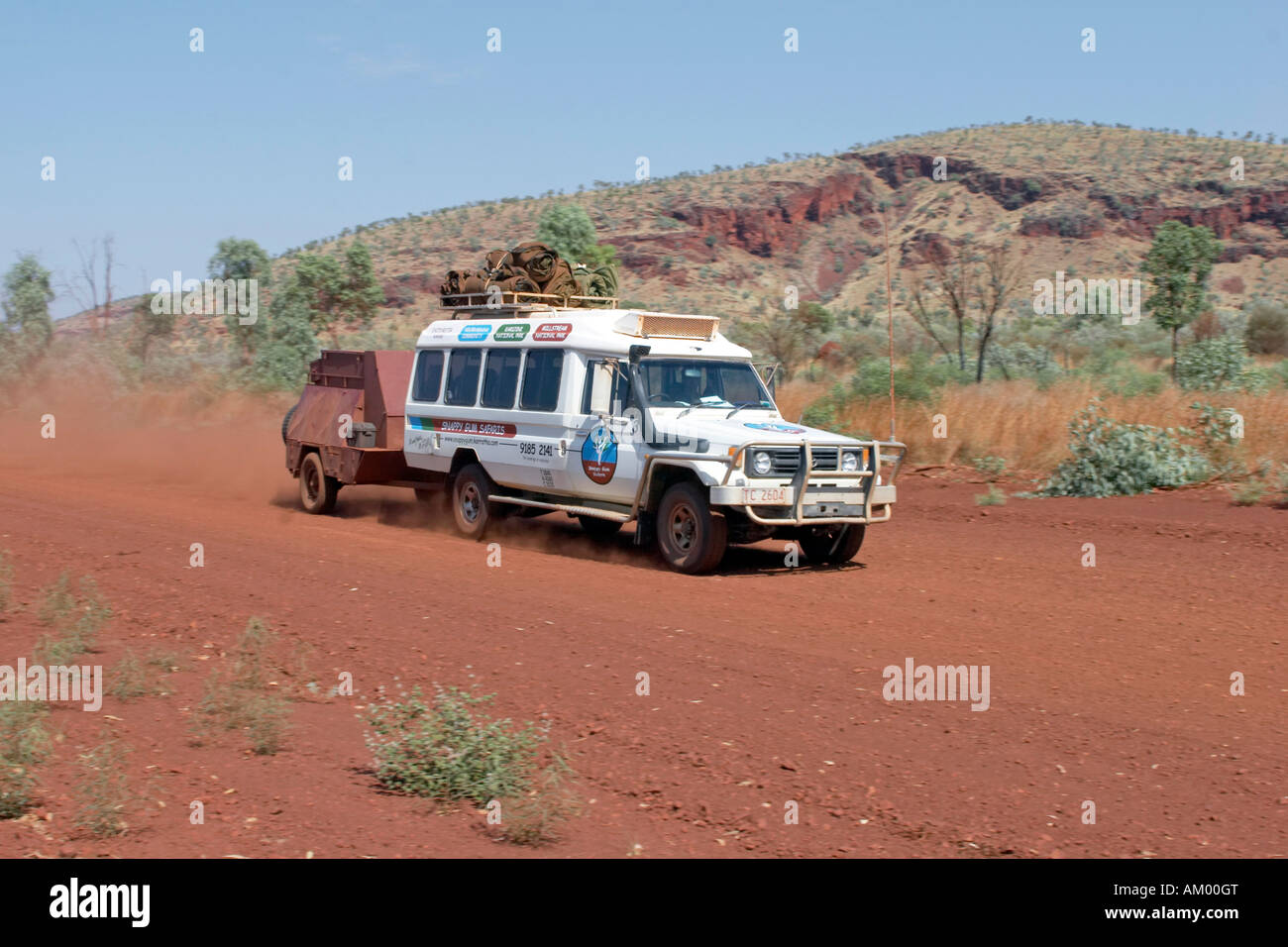 Toyota Landcruiser FJ 75 Arkana safari voiture avec remorque roulant sur une route rouge dans la région de Pilbara Parc national de Karijini western Banque D'Images