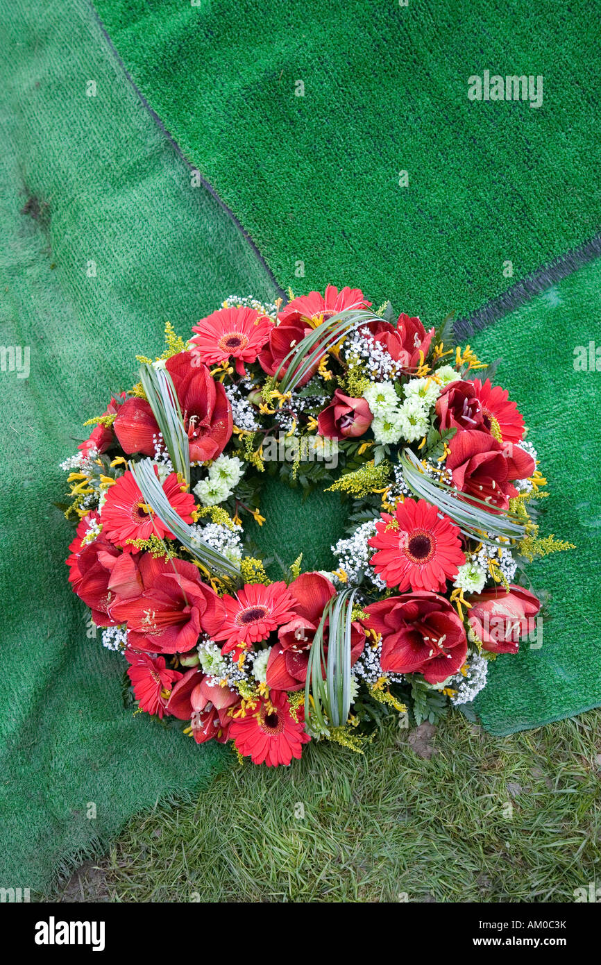 Gerbe couchée sur un tapis à côté artificiel creusé récemment de graves Pays de Galles UK Banque D'Images