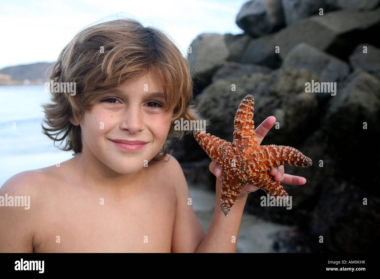Jeune garçon tenant une étoile de mer Banque D'Images