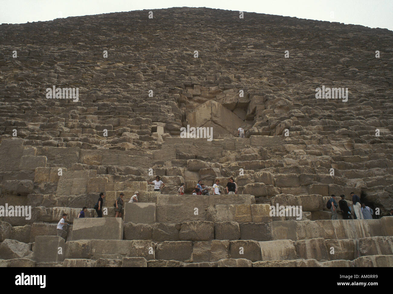 Les touristes grimper sur la grande pyramide, Giza, Egypte Banque D'Images