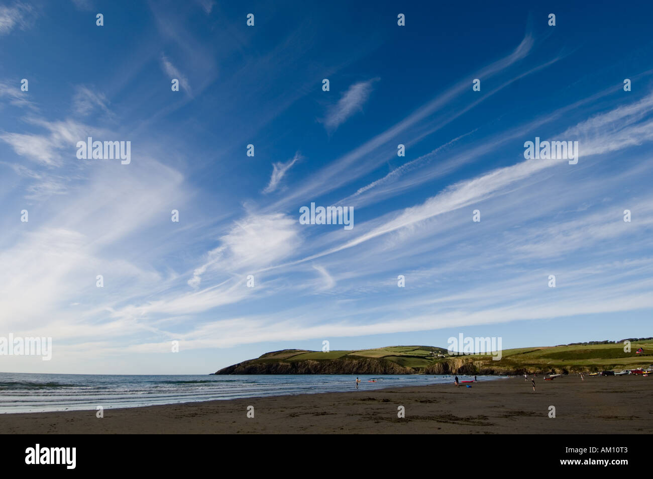 Les cirrus de haute altitude au-dessus de la plage de sable à l'ouest du pays de Galles pembrokeshire Newport UK à la fin d'une journée d'été Banque D'Images