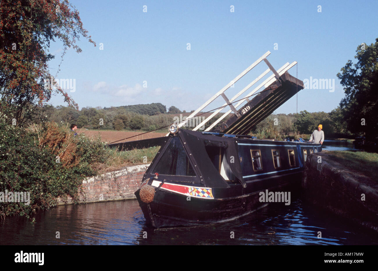 La direction de l'homme 15-04 par espace étroit sous le pont cantilever sur Oxford Canal, près de Thrupp, Oxfordshire, Angleterre Banque D'Images