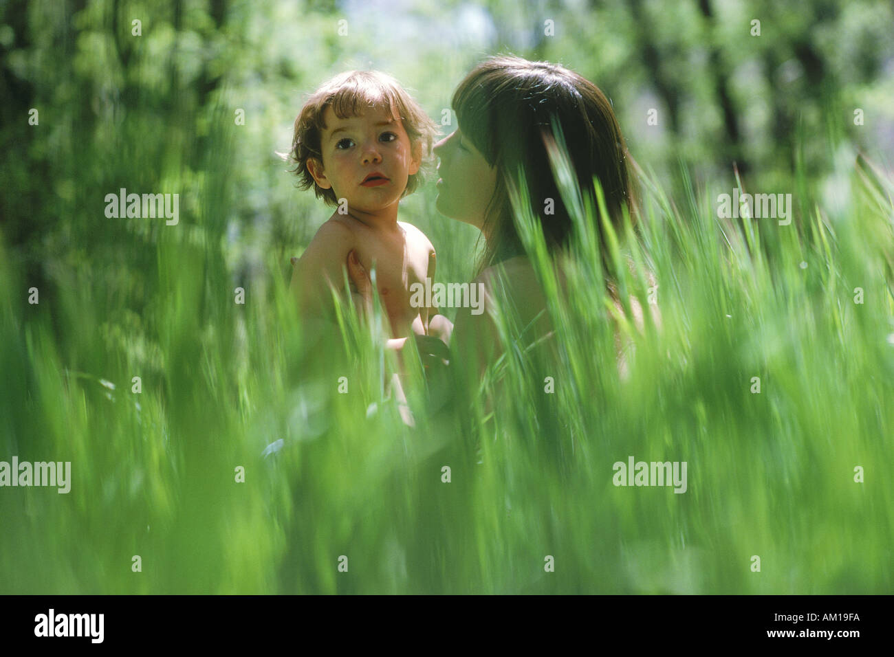 La mère et le fils assis dans domaine de la grande herbe verte Banque D'Images