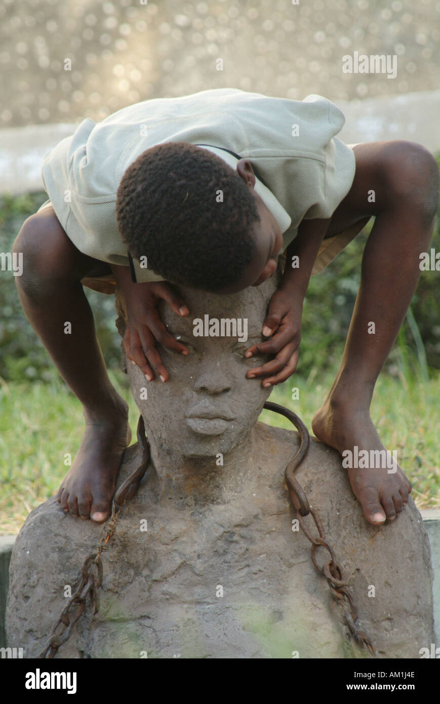 Les enfants jouent sur l'esclavage monument construit sur le site de l'ancien marché aux esclaves de Stone Town. Zanzibar, Tanzanie, Afrique de l'Est Banque D'Images