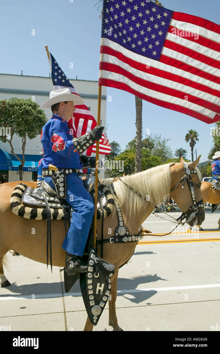 Cowboys marchant avec des drapeaux américains affiché durant le jour d'ouverture défilé dans State Street Santa Barbara CA Vieux jours Espagnol Banque D'Images
