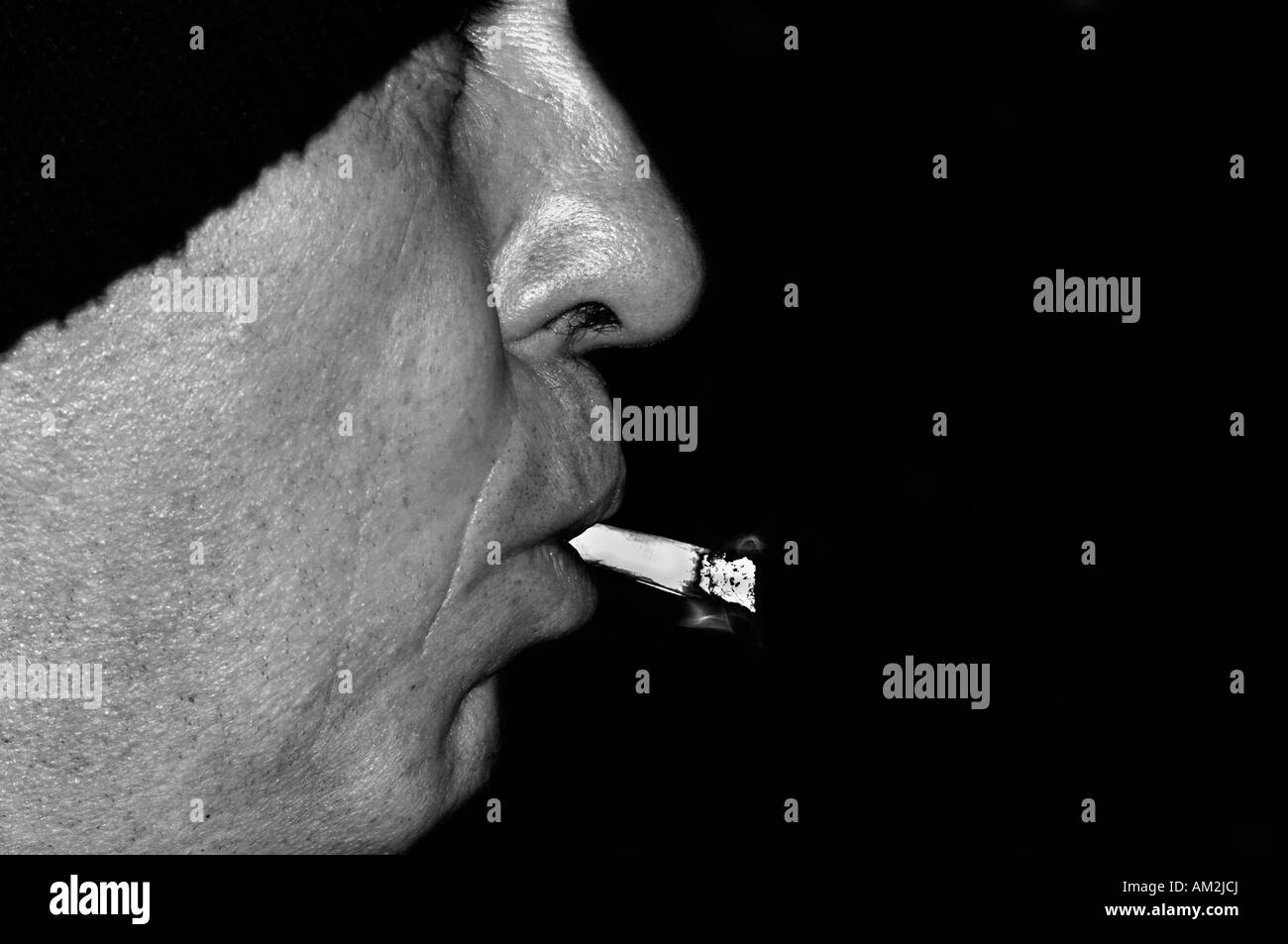 Un homme qui fume une cigarette Rollup non filtré. Banque D'Images