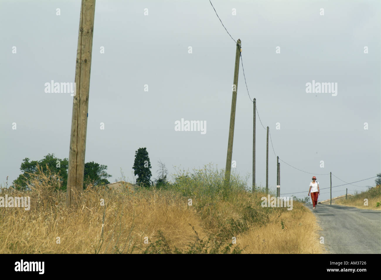 La France près de Carcassonne Alzonne hauts femme marche sur une route de campagne Banque D'Images