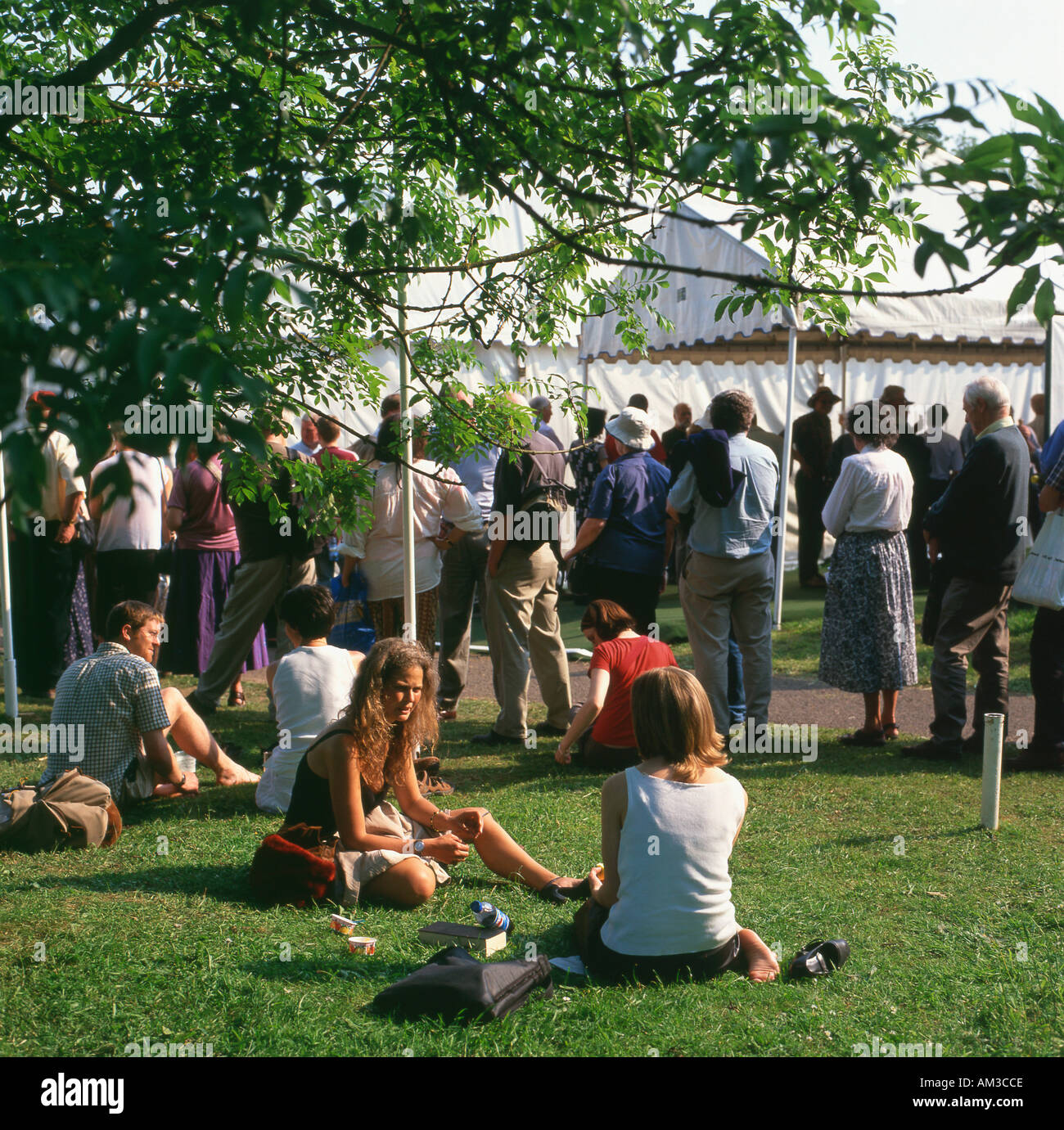 Les gens font la queue pour événements et assis sur la pelouse à l'Hay Festival, Hay-on-Wye, Powys Pays de Galles UK Banque D'Images