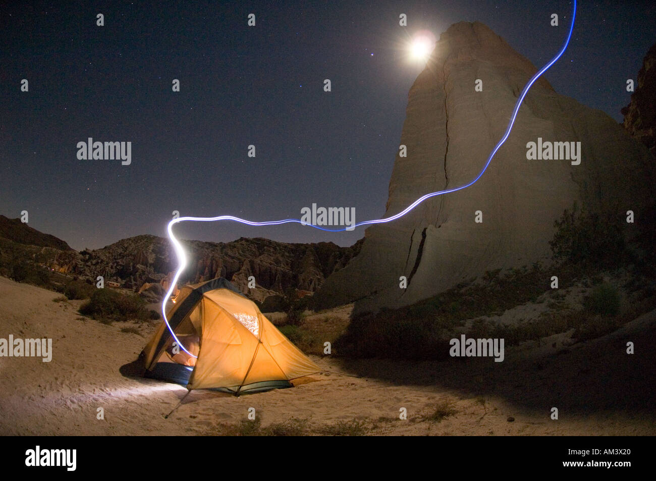 Desert camping avec tente éclairée par la lune et trail de projecteur de nuit, Red Rock Canyon state aire de loisirs en Californie Banque D'Images