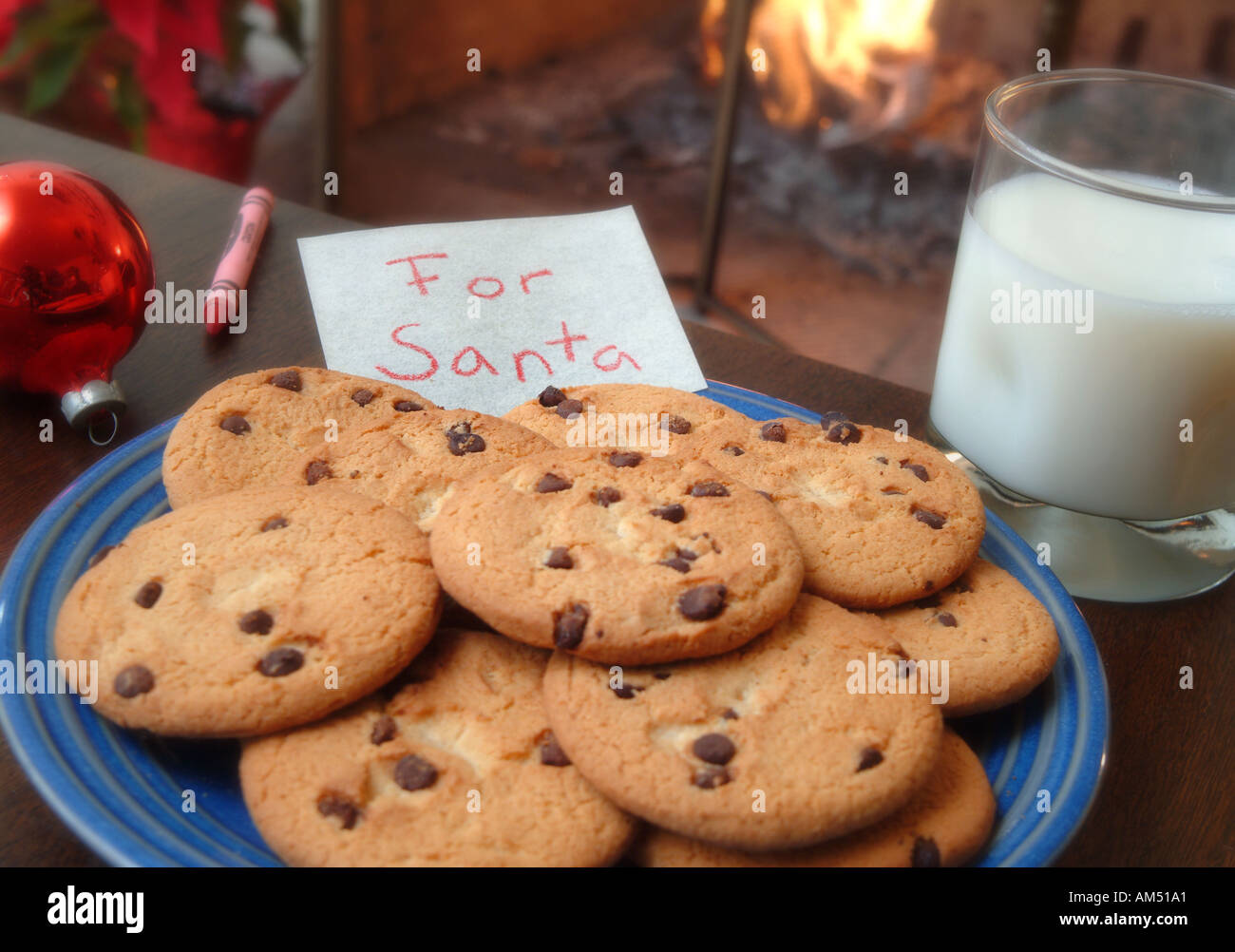 Une plaque de biscuit aux brisures de chocolat à gauche pour le Père Noël avec un verre de lait et une note. Banque D'Images