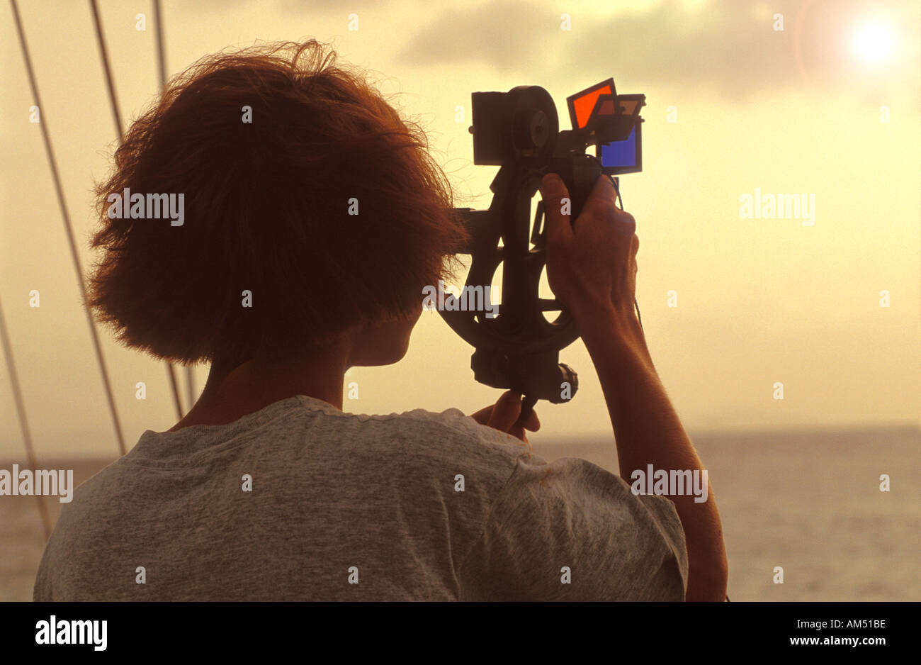 Une jeune femme à l'aide d'un sextant à bord d'un voilier Banque D'Images