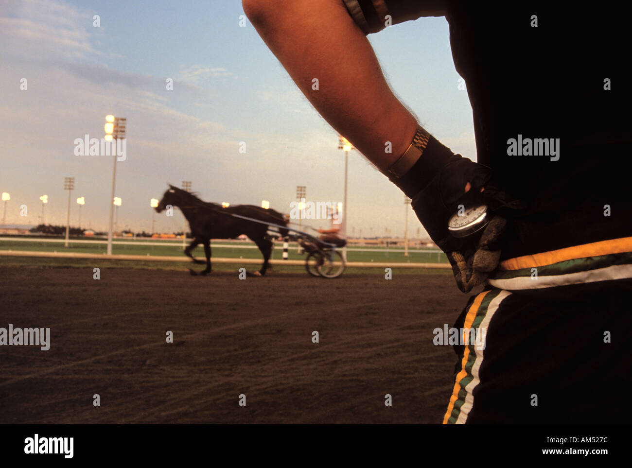 Une fois l'entraîneur de chevaux de course au trot sur la piste avec un chronomètre Banque D'Images