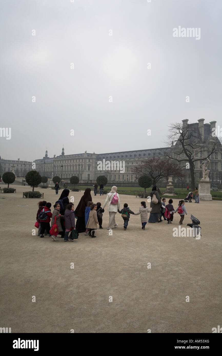 Jeunes femmes musulmanes et les enfants de maternelle ou crèche groupe au jardin des Tuileries, paris france Banque D'Images