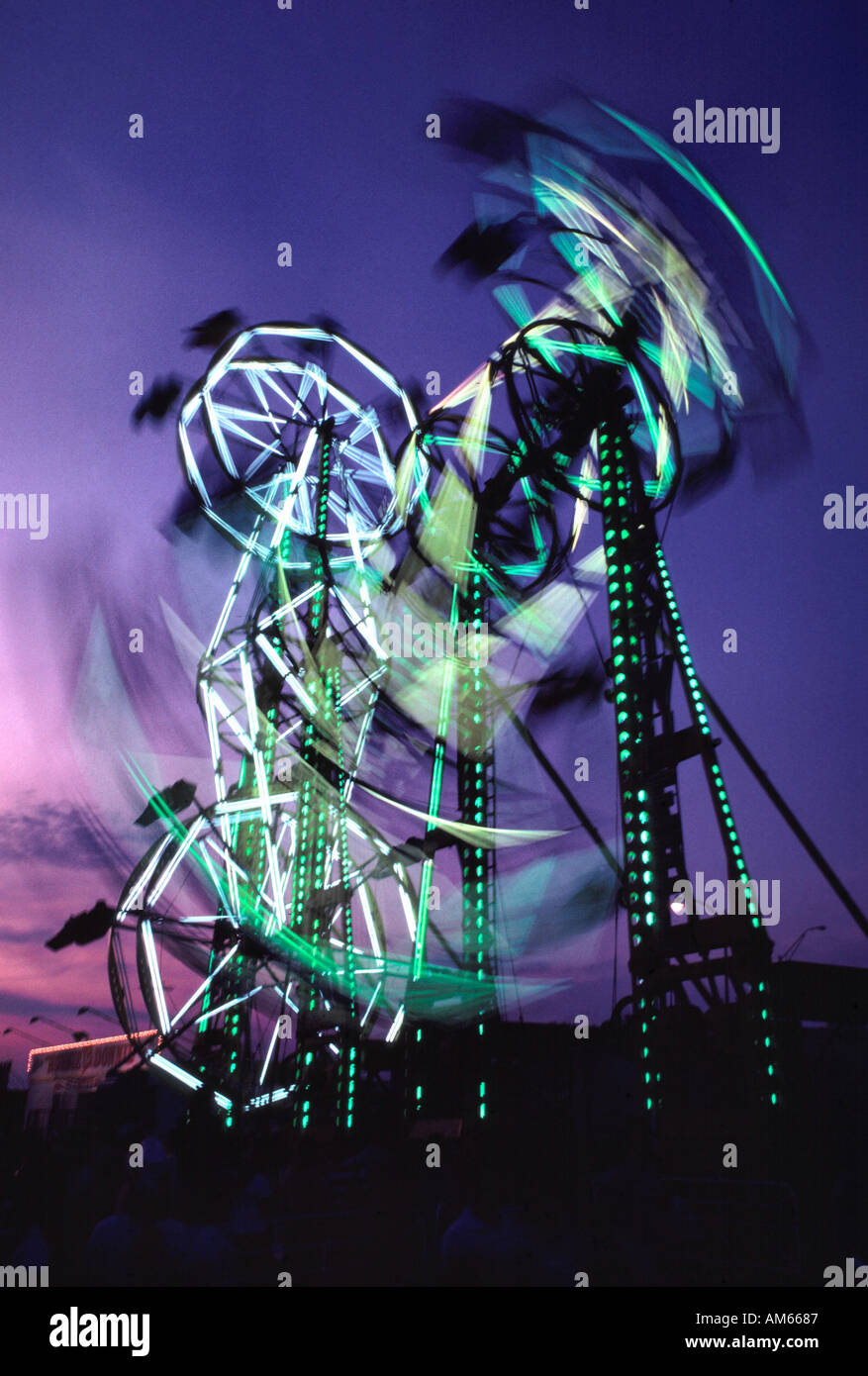 Carnival midway double ferris wheels in motion la nuit Banque D'Images