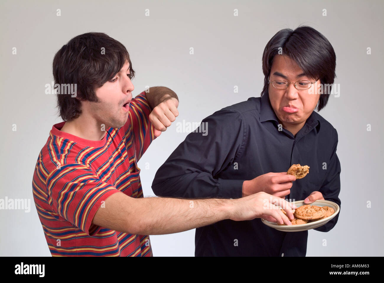 Deux garçons qui se battent pour les cookies et nerd étudiant conservateur Banque D'Images