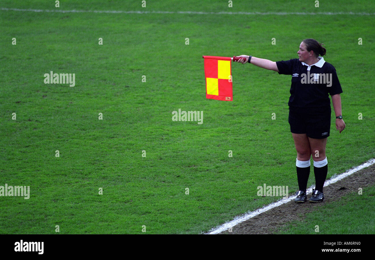 Les signaux de l'arbitre féminine sous-hors-jeu lors d'un match de football amateur dans la région de Harwich, Essex, Royaume-Uni. Banque D'Images