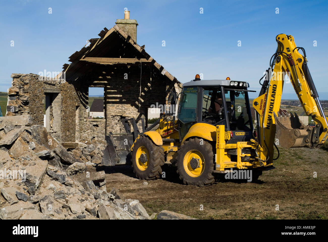 Dh Digger tracteur CONSTRUCTION Démolition Démolition britannique ancien bâtiment démoli Orcades débris clair Banque D'Images