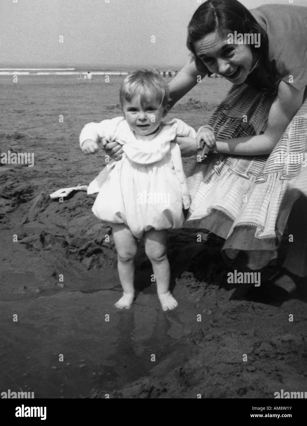 OLD VINTAGE SNAPSHOT FAMILLE PHOTOGRAPHIE DE JEUNE MÈRE HOLDING BABY BOY SUR LA PISCINE SUR LA PLAGE Banque D'Images