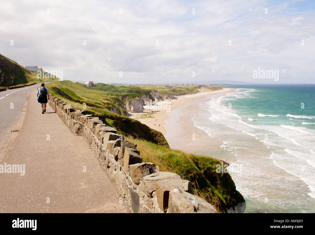 Irlande. Walker sur North Antrim Coast Road, Portrush. Sur East Strand aux White Rocks, en regardant vers le sud-ouest jusqu'à la ville de Portrush au-delà Banque D'Images
