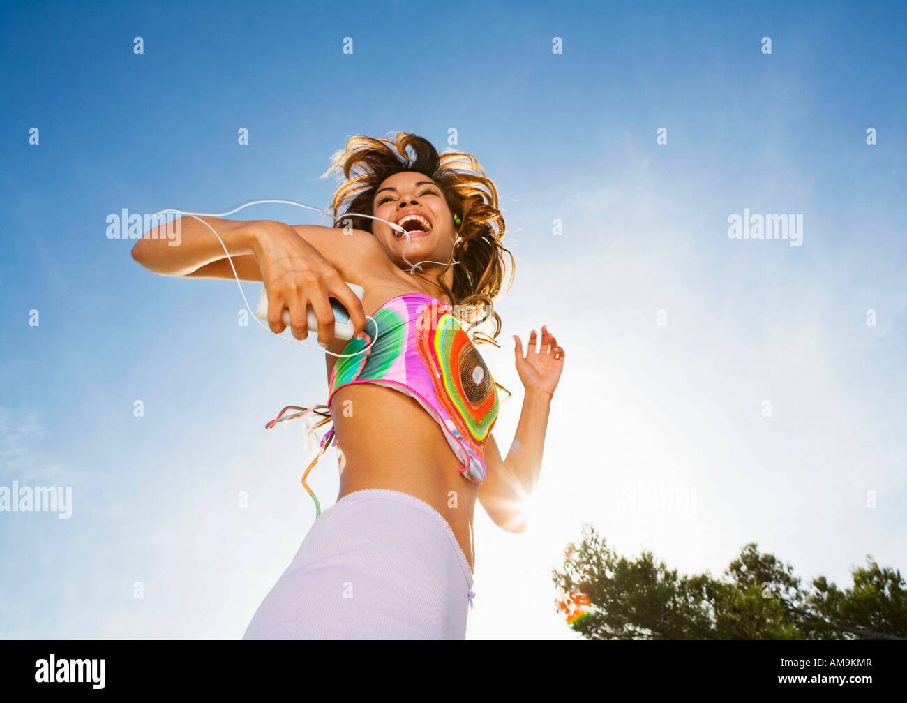 Femme énergique danse sur MP3 player outdoors smiling. Banque D'Images