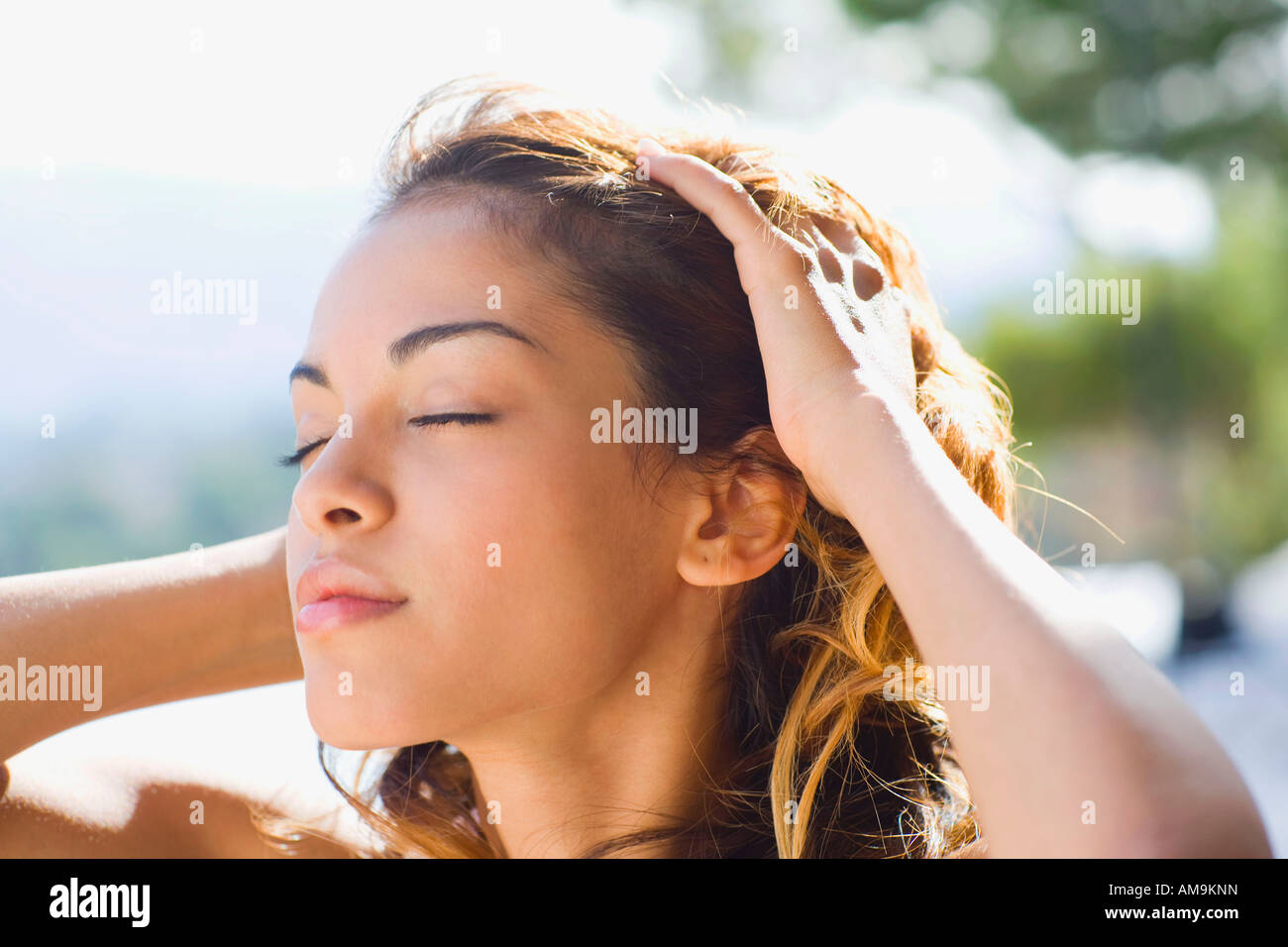 Femme à l'extérieur avec les mains sur la tête. Banque D'Images