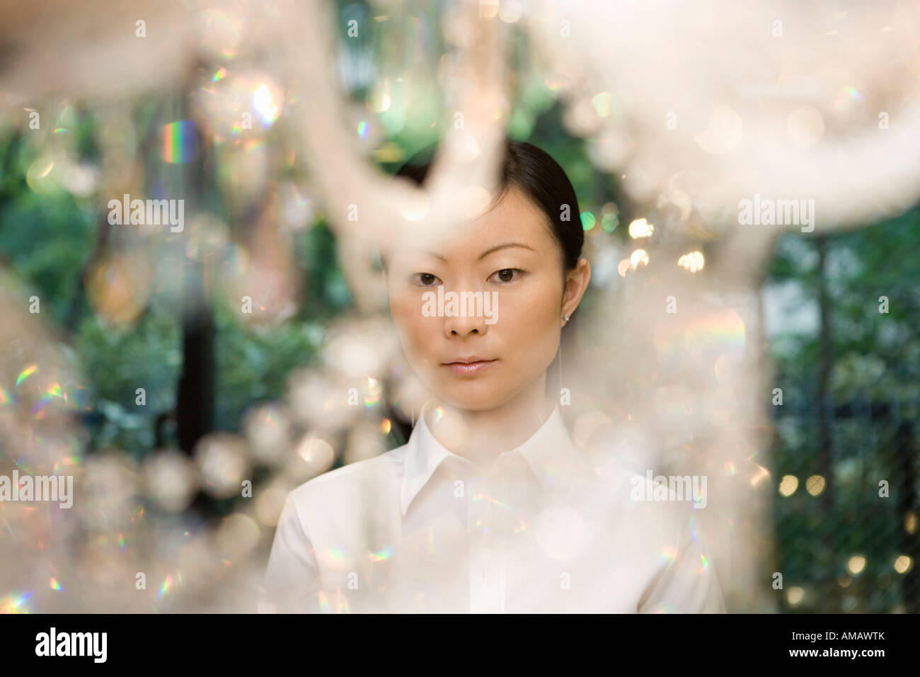 Une femme à côté d'un lustre Banque D'Images