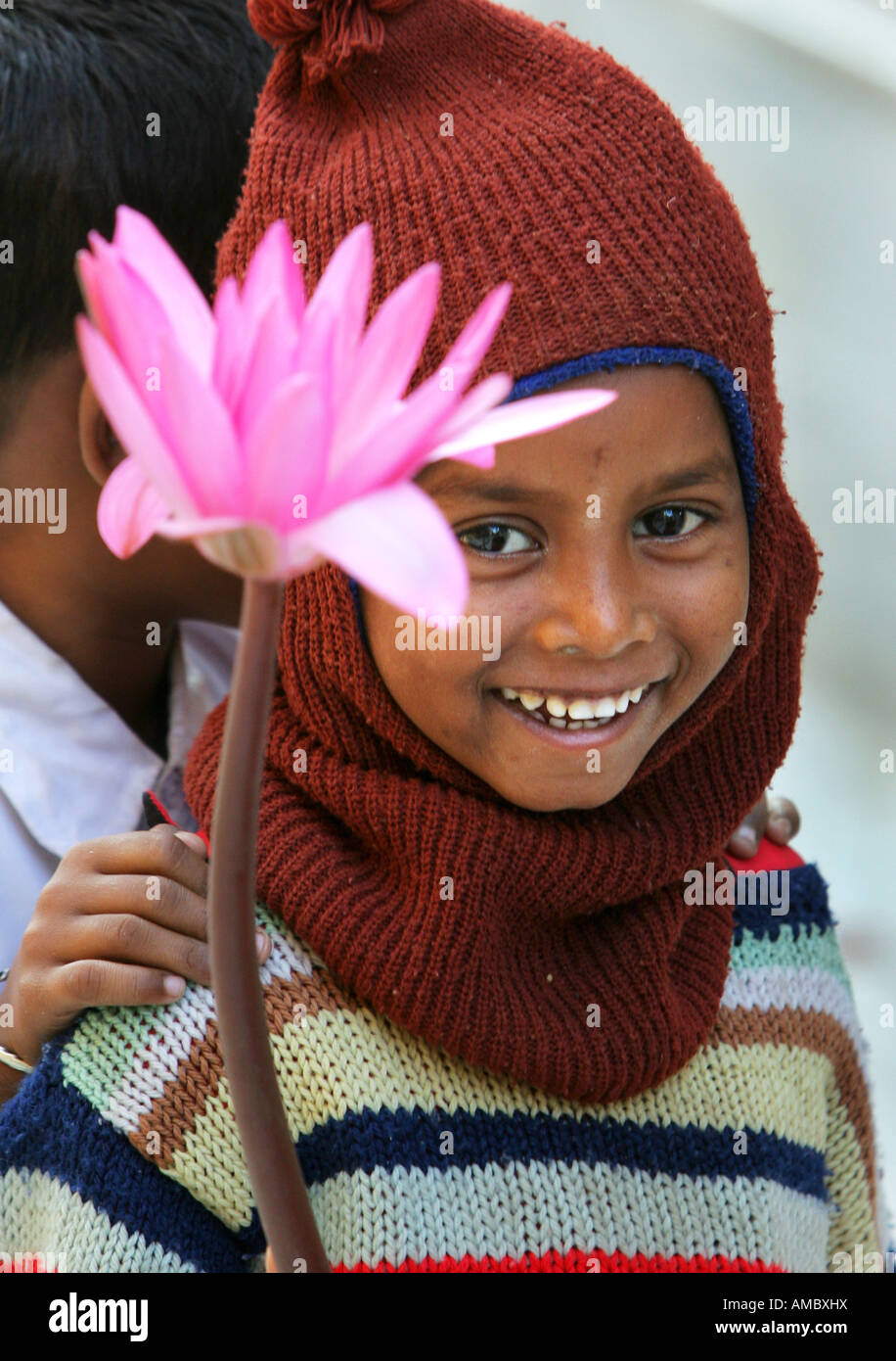 L'Inde, Bodhgaya : jeune garçon bouddhiste avec des fleurs de lotus se rendant sur le site du temple de la Mahabodhi Banque D'Images