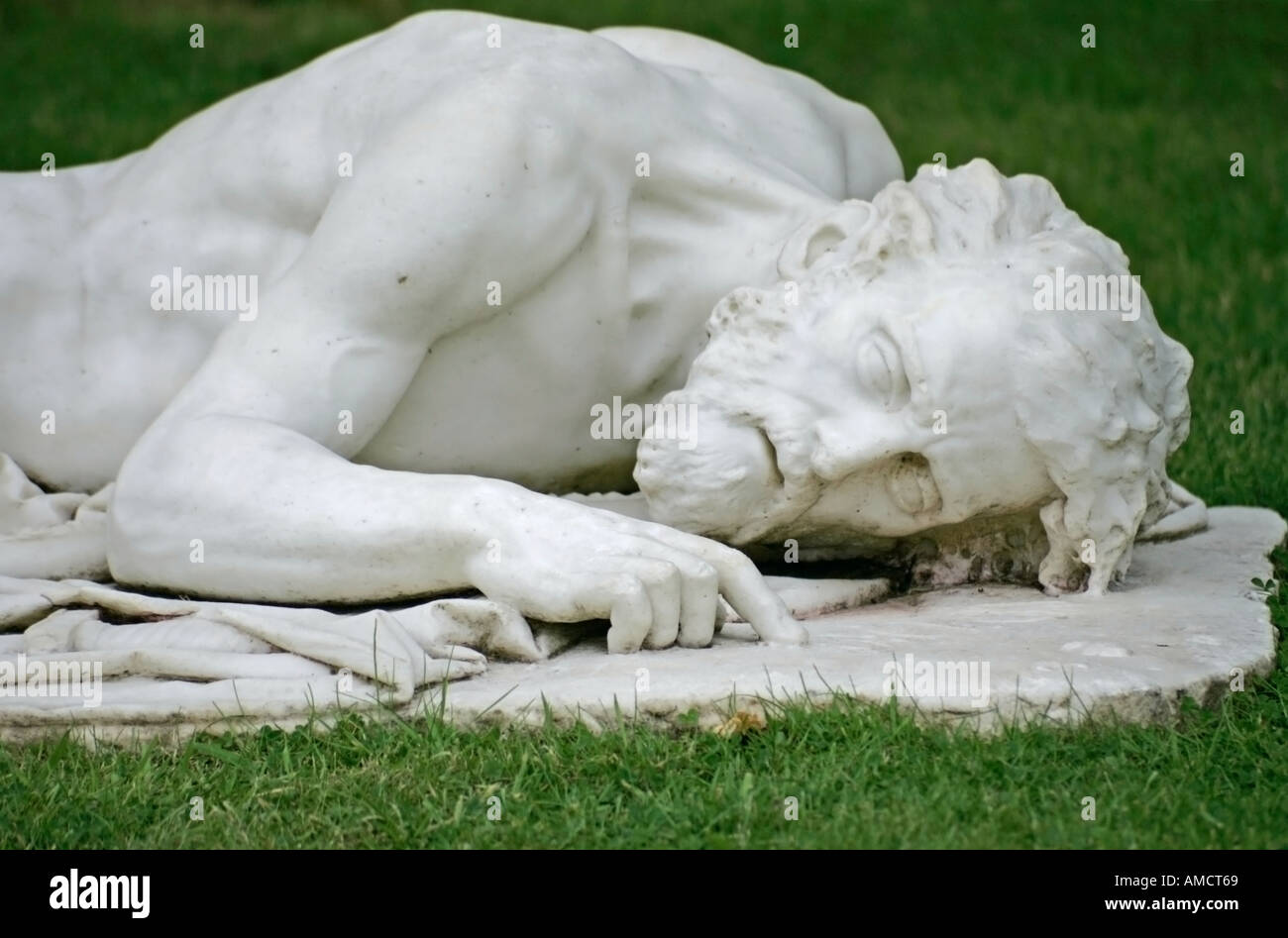 Sculpture en marbre blanc d'un homme habillé semi allongé sur l'herbe. Parham House, Sussex Banque D'Images