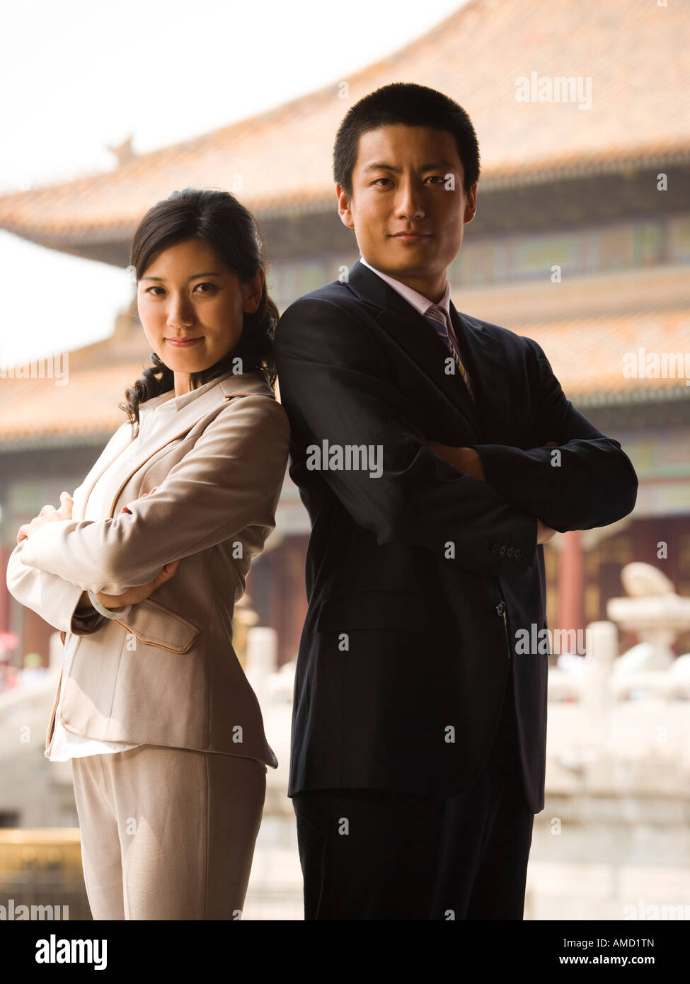 Businessman and woman standing with arms crossed et dos avec pagoda en arrière-plan Banque D'Images