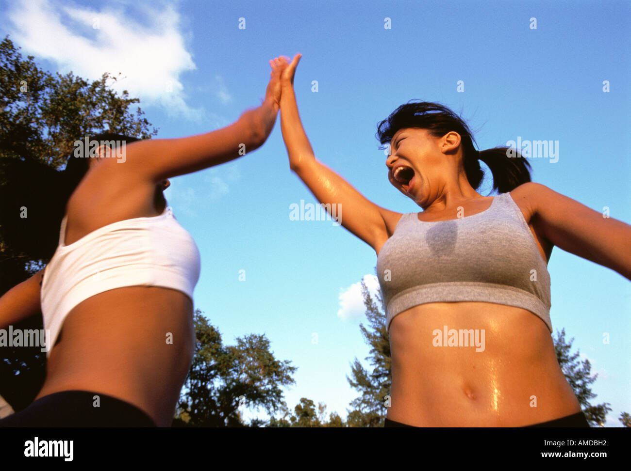 Deux femmes donnant à l'extérieur transpirant High Five Banque D'Images