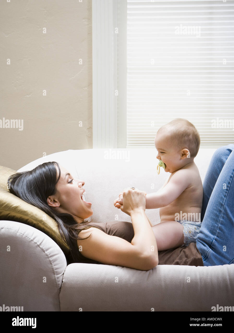 Femme allongée sur le canapé avec bébé Banque D'Images