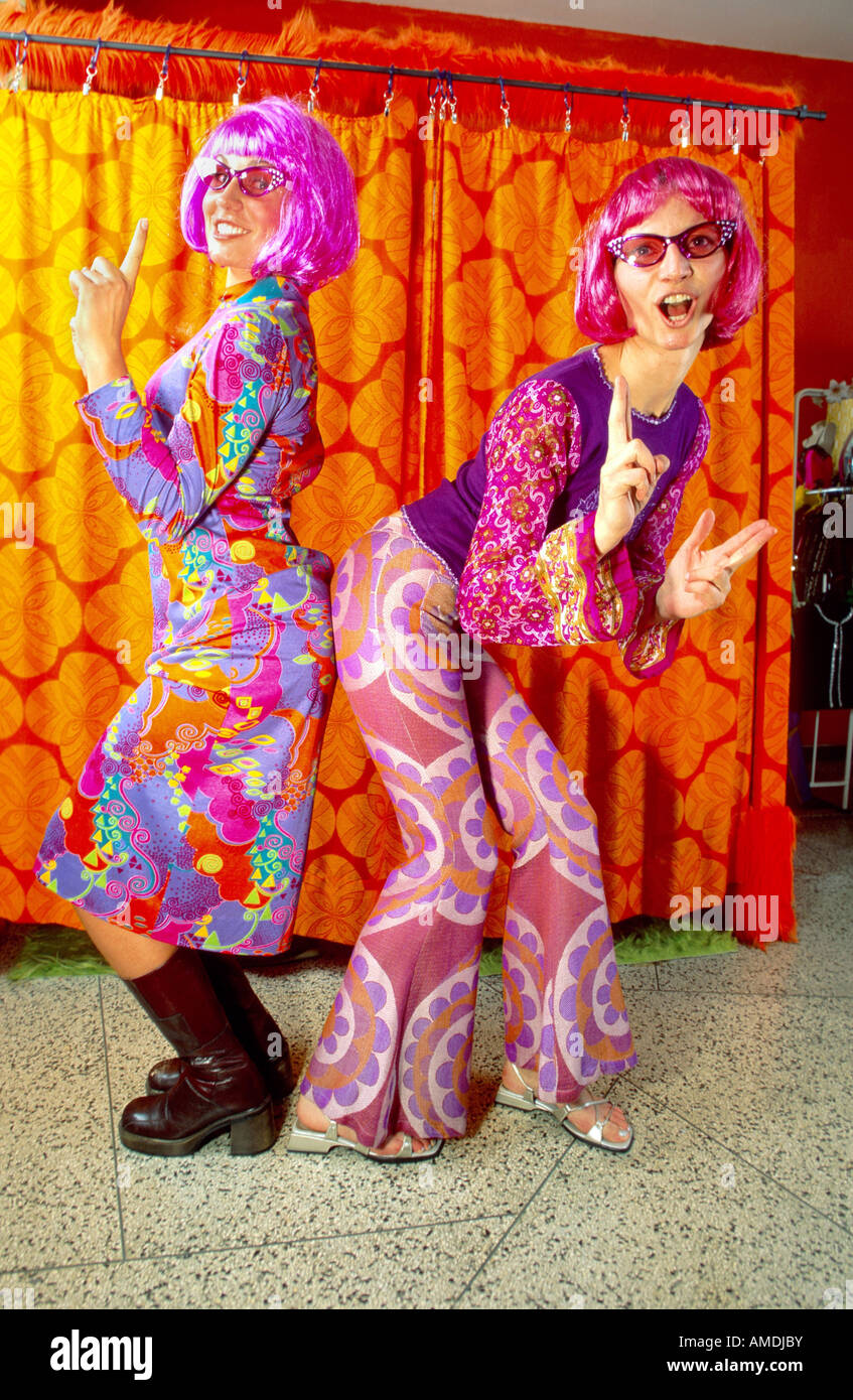 Deux femmes avec des brindilles rose portant des annees 70 vetements et lunettes de soleil danser cote a cote se frotter les fesses a chaque othe Photo Stock Alamy