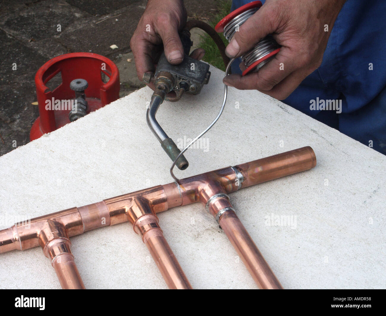 Close up de plombier à l'aide d'un chalumeau pour chauffer au gaz propane  pour faire une soudure sur les articulations capillaire de tuyaux en cuivre  de la tuyauterie à souder ensemble de